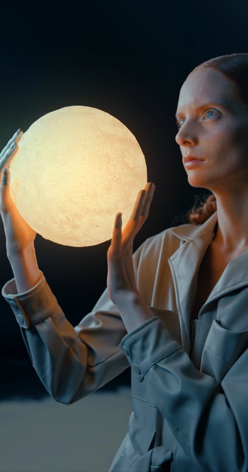 A Woman Holding The Moon In A Conceptual Video