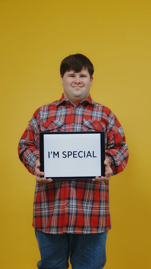 Young Man Holding a Tablet While Poses On Camera