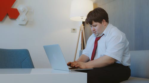 Man Seated Typing On Laptop