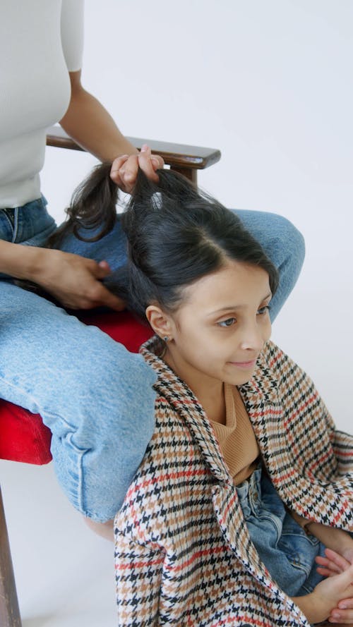 A Mother Tying Her Daughters Hair