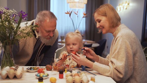 Grandparents Helping a Girl Decorate an Egg