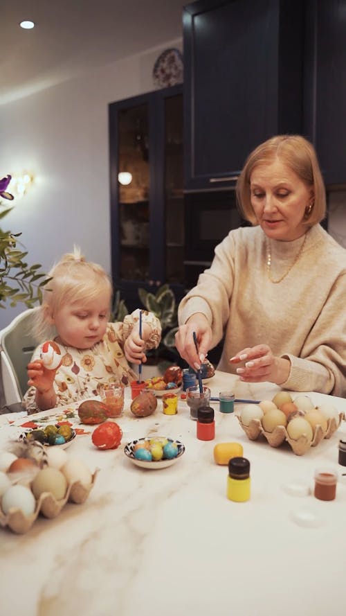 Woman Painting an Egg with a Girl