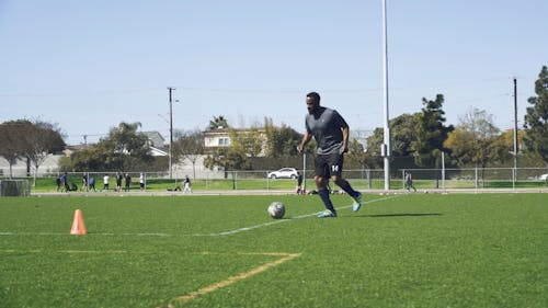 Man Training Soccer on a Soccer Field