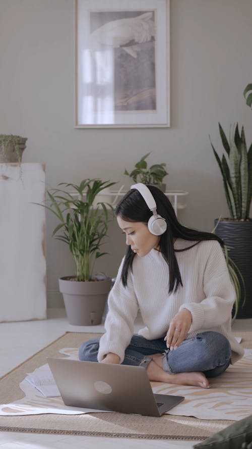 Woman Wearing Headphones Using a Laptop