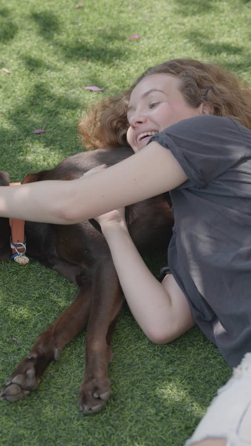 Woman and Dog Lying Down on the Grass