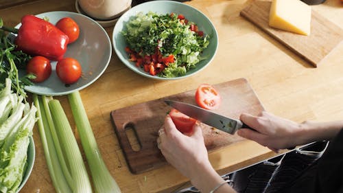 Person Slicing a Tomato