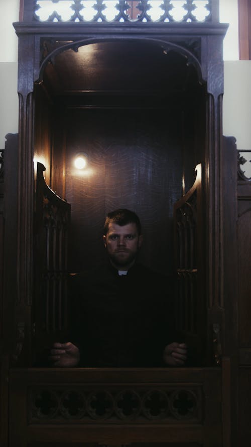 Priest in Wooden Confessional