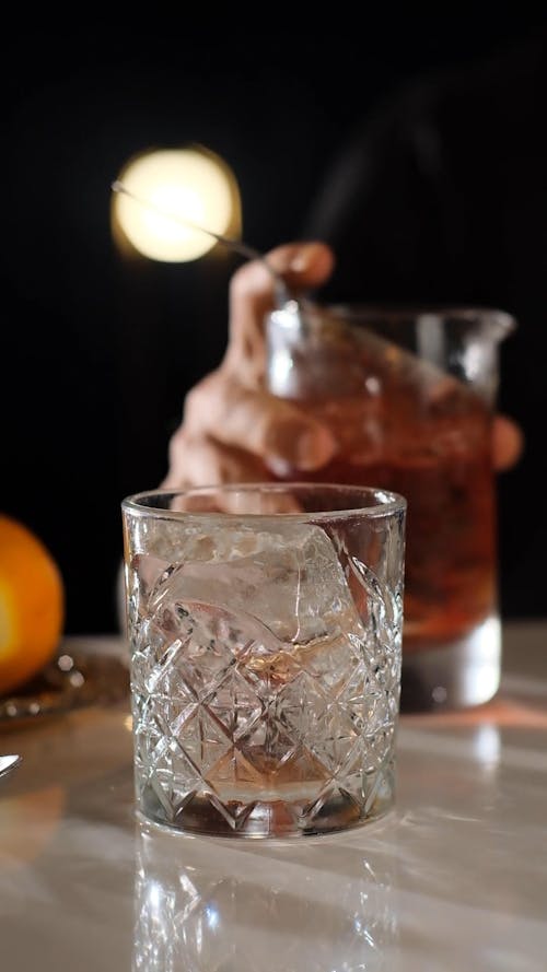 Pouring a Cocktail Drink on a Crystal Glass