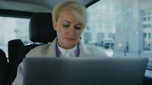 A Woman Working while Riding a Car