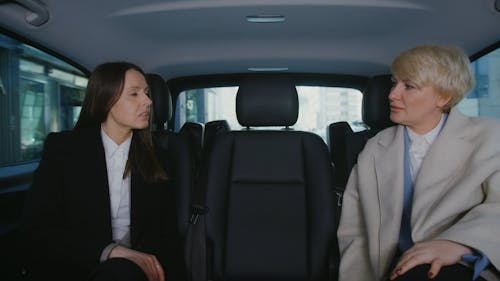Businesswomen Talking in the Back Seat of a Moving Car