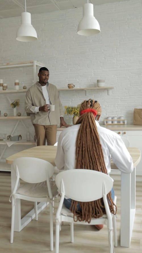 A Woman Sitting and a Man Talking While Standing