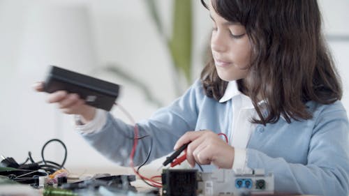 A Kid Using a Electrical Tester
