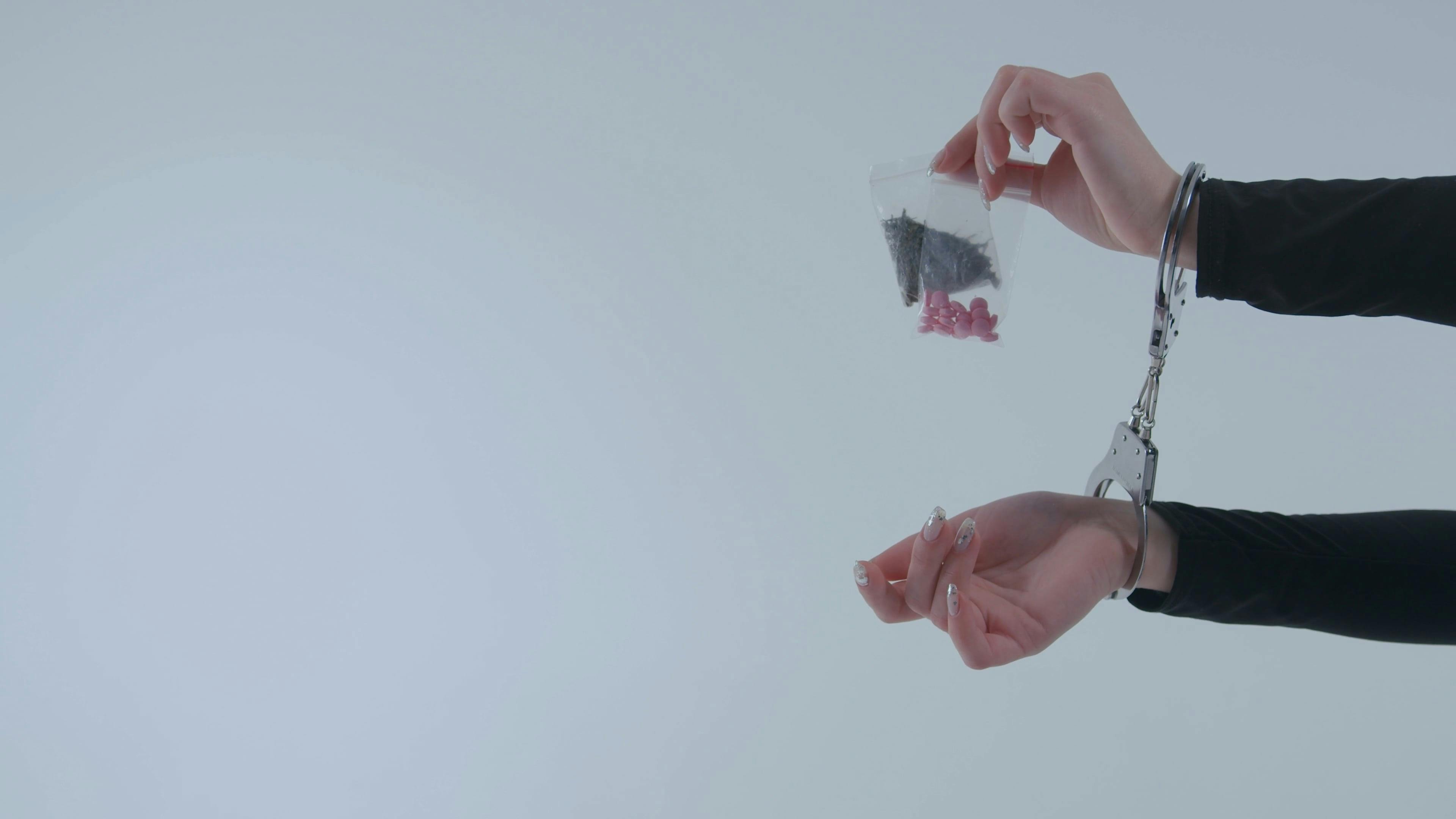 Person in Handcuffs Holding Packs of Illegal Drugs · Free Stock Video