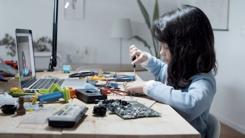 Girl Working with Computer Pieces 