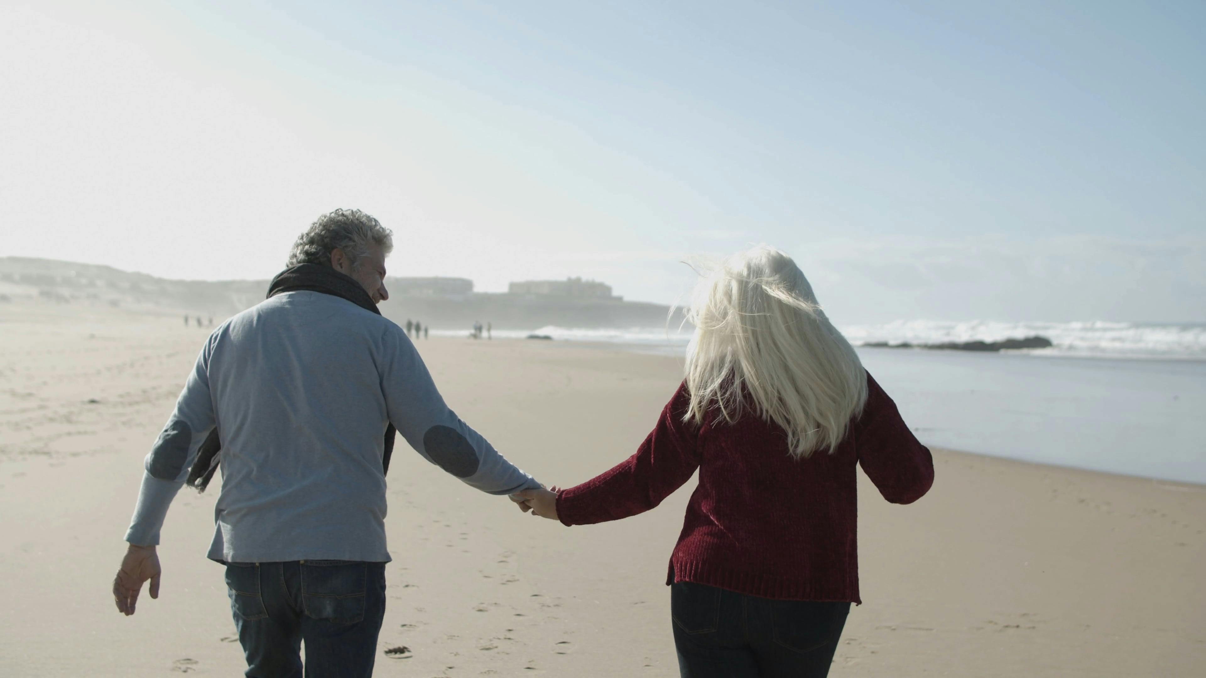 Elderly Couple Enjoying Running On The Beach Sand · Free Stock Video