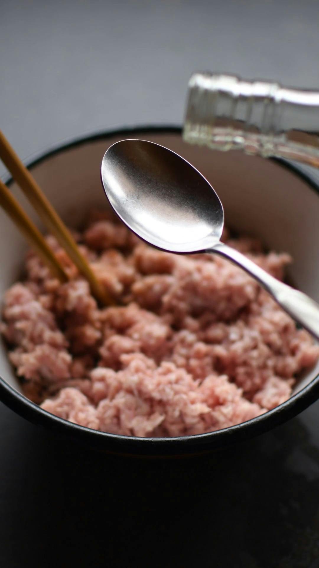 A Person Adding Light Soy Sauce to the Minced Meat · Free Stock Video