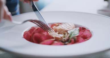 close up shot of a person eating salmon in the restaurant