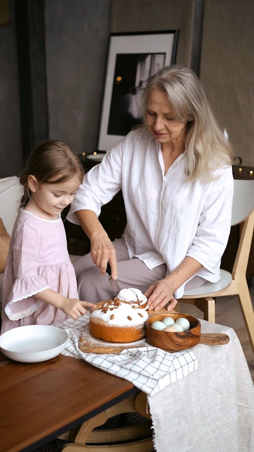A Grandmother Slicing a Cake for Her Granddaughter