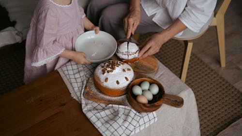 An Elderly Slicing and Placing a Baked Good on a Kid's Bowl
