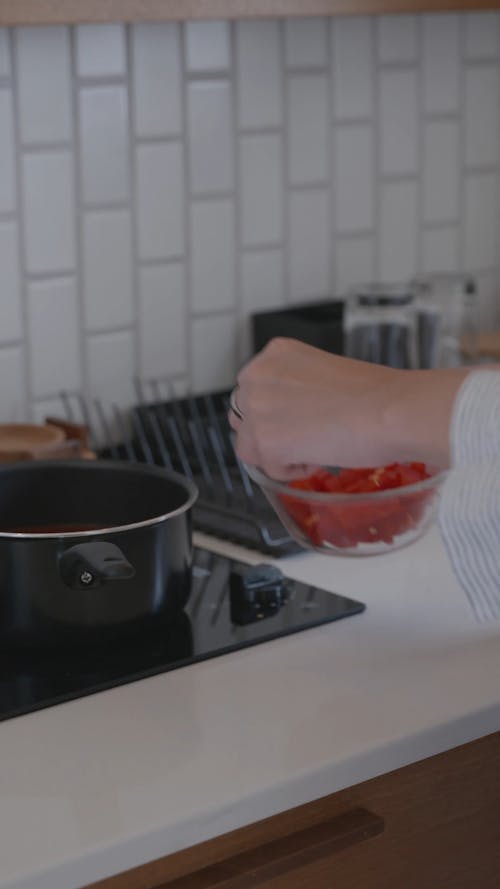 A Woman Putting Tomatoes on a Pan