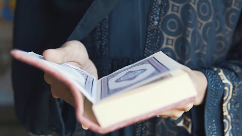 A Person Holding a Quran Book