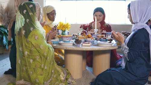 Group Of Women Praying Before Meal