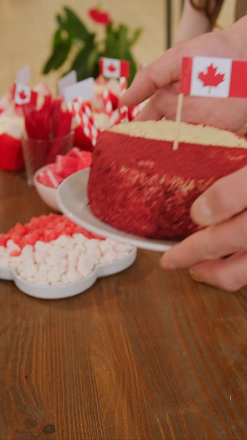 A Person Putting a Cake on the Table 