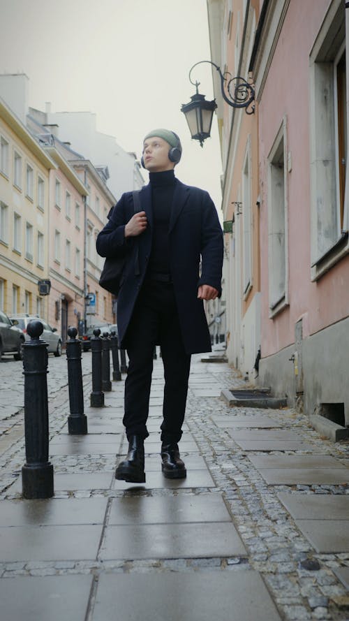 Young Man Walking on Pavement