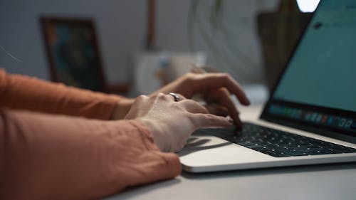 A Person Typing on a Laptop