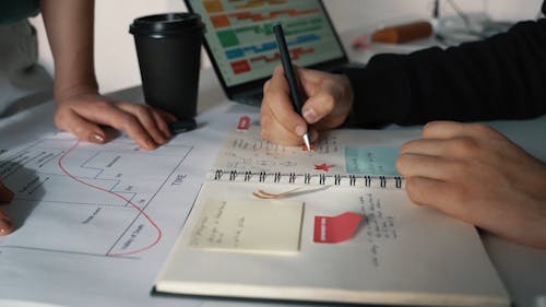 Person at the Office Taking Notes in Notebook