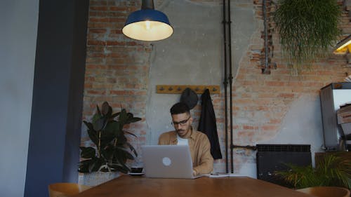 Man Using a Laptop In a Café