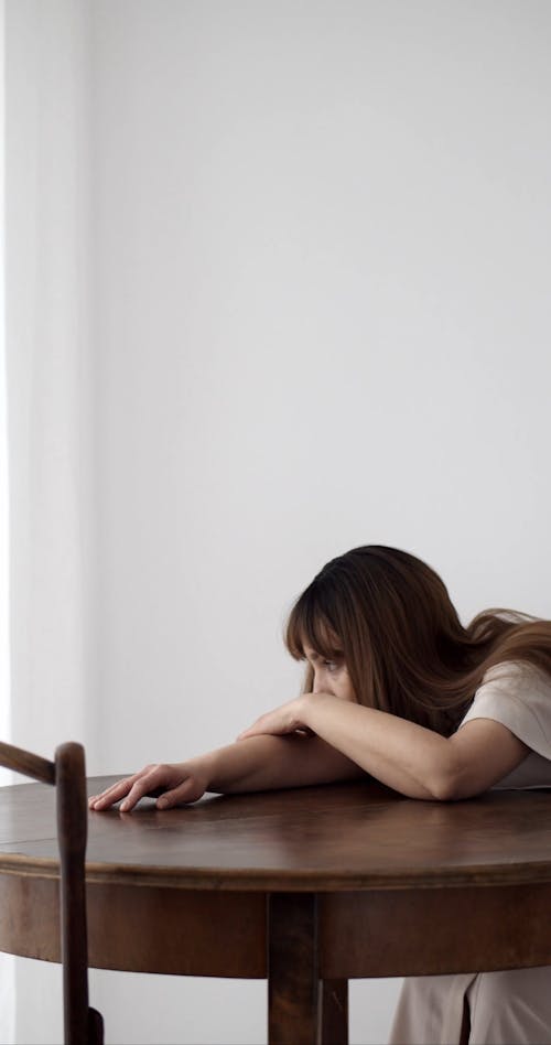 A Woman Who Looks Depressed Leaning on the Table