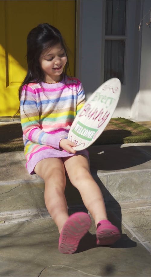 A Girl Holding an Egg Shaped Easter Decoration