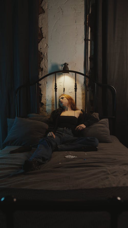 A Depressed Woman Lying on Bed with Pills