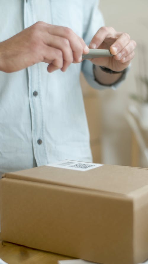 Man Taking Photo of the QR Code on the Box