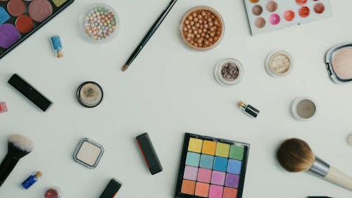 Red Lipstick and Cosmetic Products on White Surface