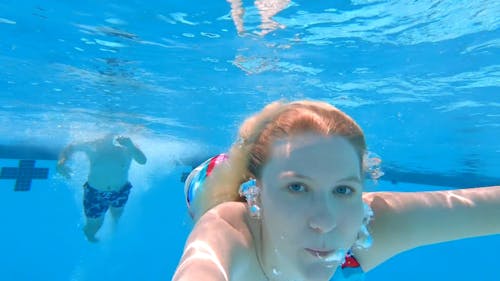 A Woman Taking A Selfie While Swimming Underwater