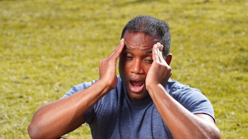 Man with Headache Massaging His Head