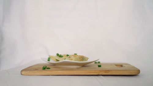 Person Picking Dumpling With Chopsticks