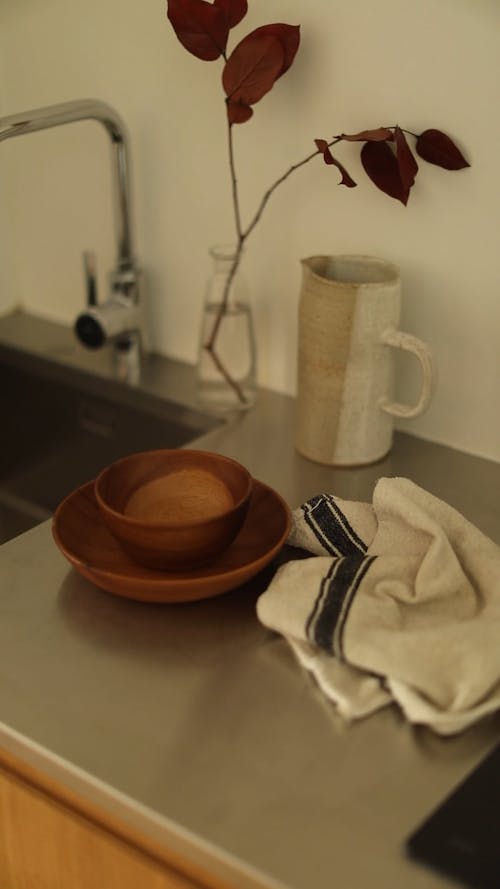 A Wooden Bowls and a Kitchen Towel on Top of a Stainless Steel