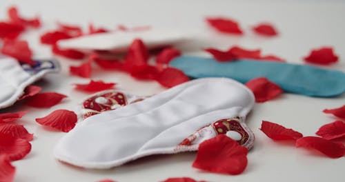 Red Petals Falling on a Cloth Napkin and Pills 