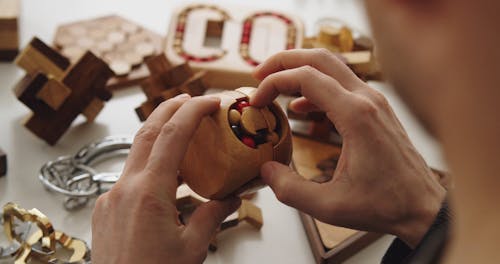 Person Solving a Wooden Puzzle