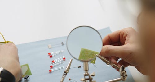 A Electrician is Working while Checking in Magnifying Glass