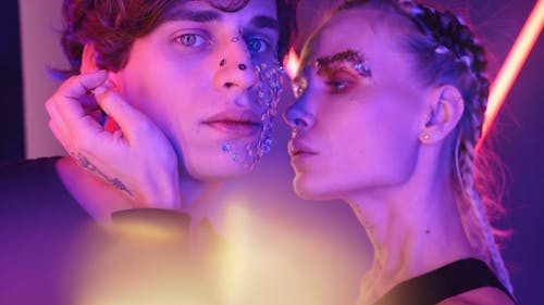 Couple with Glitters and Tattoo in a Room with Neon Lights