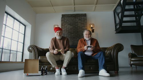 Men Sitting on a Sofa Playing Video Games