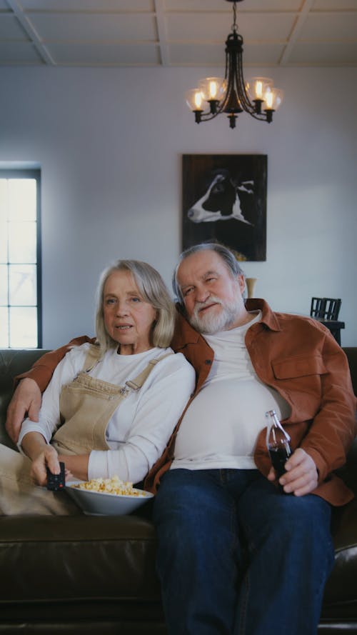 Couple Sitting on a Sofa While Watching