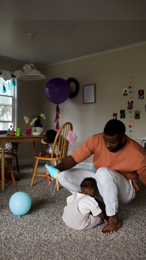 A Father Putting a Party Hat on a Baby