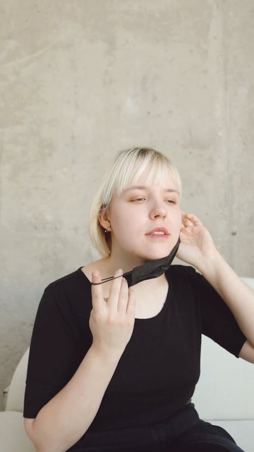 A Woman Putting On Face Mask