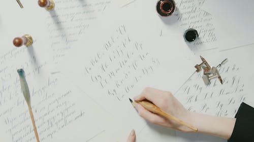 A Person Writing with an Antique Dip Pen and Ink 