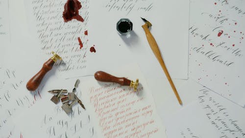 Overhead Shot of a Dip Pen and Seals on Ink Stained Papers